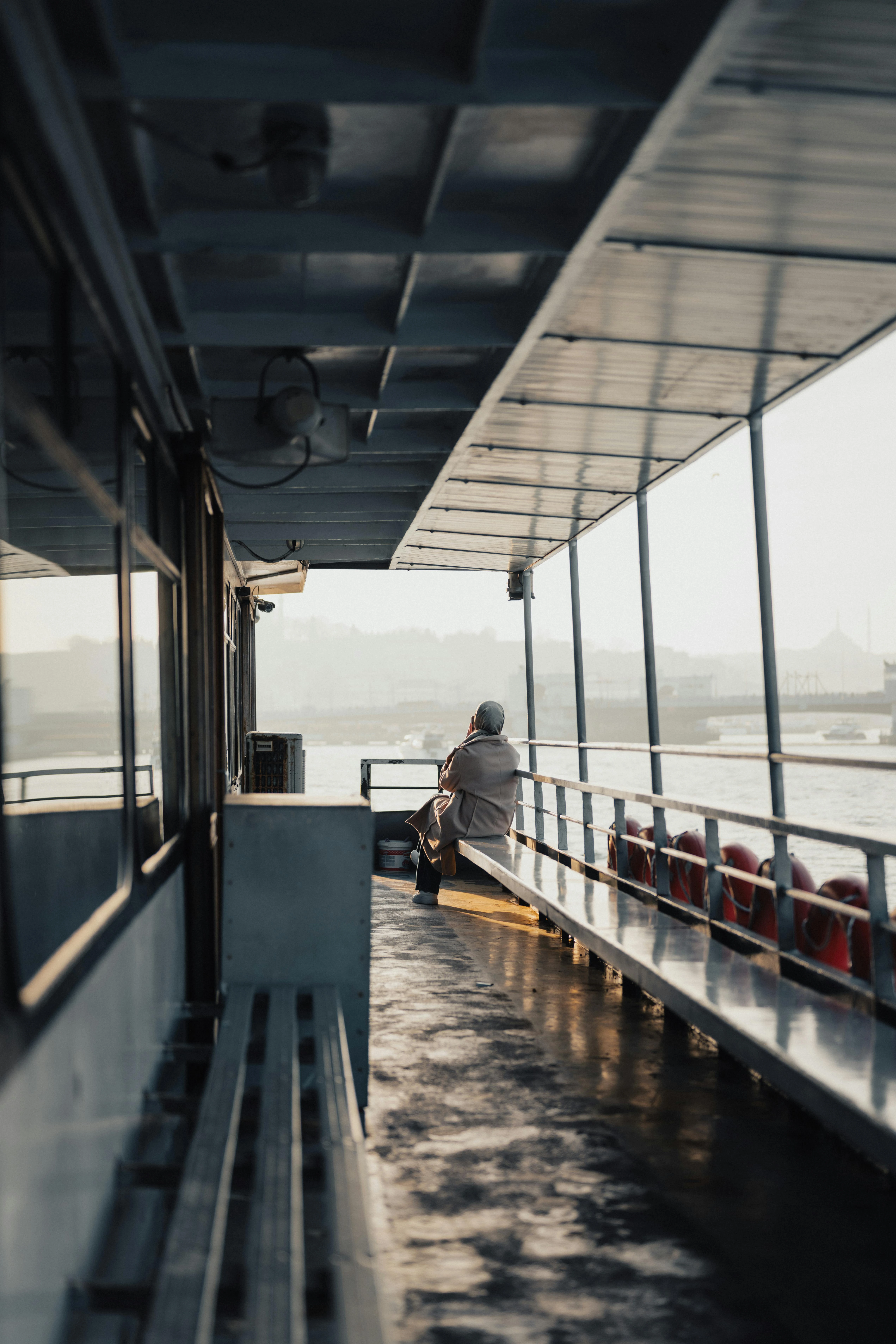 a person sat observing the view from the deck of a ferry